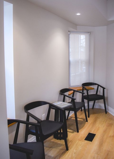 waiting room with 4 black chairs with rounded backrests